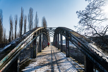 man walking on steel bridge in winter
