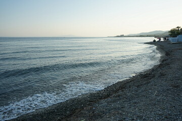 Blick vom Strand in Altinoluk mit Angler im romantischen Licht der untergehenden Sonne auf den Golf...