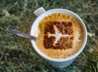 Closeup of a cappuccino with an aeroplane stencil foam
