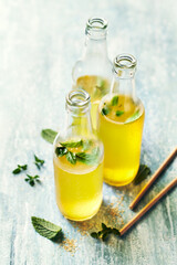 Homemade iced tea with lime, mint and brown sugar i glass bottles
