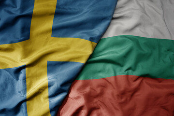 big waving national colorful flag of sweden and national flag of bulgaria .