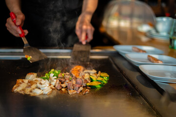 Chef cooking in Japanese teppanyaki restaurant