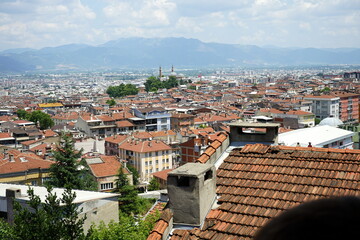 Panoramablick über alte rote Ziegeldächer auf die Stadt und das Uludag Gebirge aus einem Café...