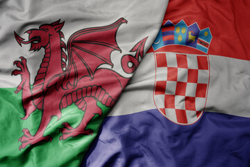 big waving national colorful flag of wales and national flag of croatia .