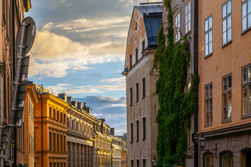 The sun shines on a row of apartments in a narrow alley at the twilight hour in the historic...
