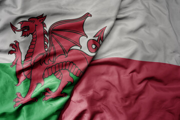 big waving national colorful flag of wales and national flag of poland .