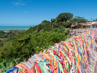 View of the beach in Bahia, Brazil. Lots of colorful wishes from tourist in the wind.