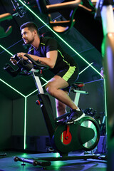 Man training on exercise bike in fitness club