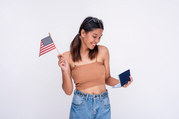 A happy asian woman checking her newly acquired US passport while waving the American flag. Focus...