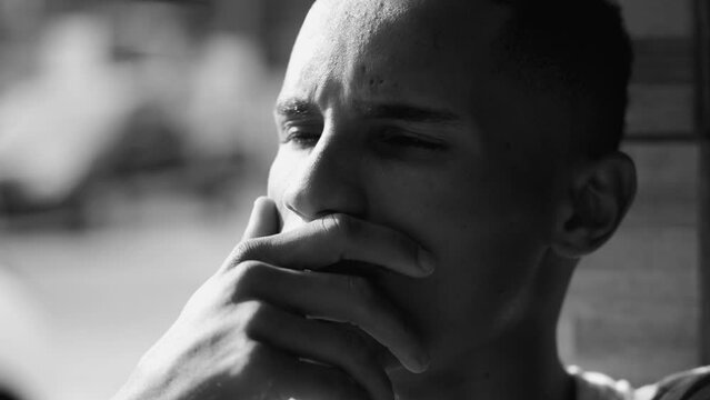 Thoughtful African American young man in black and white, dramatic monochromatic. Pensive person in deep mental reflection, contemplative gaze