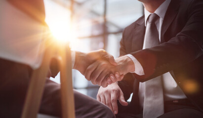 Close up businessman shaking hands with caucasian client.