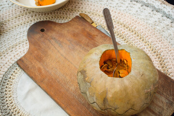 uncovered pumpkin on table with teaspoon inside, copy space