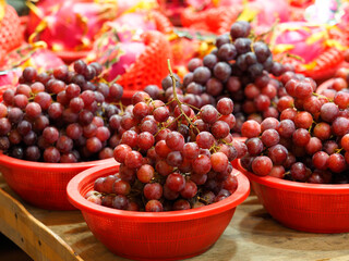 Fresh red grapes in basket, traditional market
