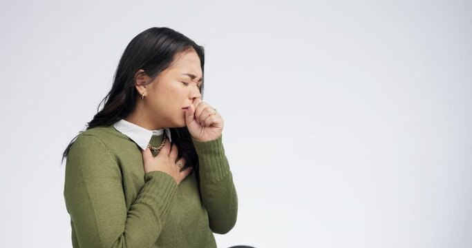 Sick, cough and woman with virus, asthma and health issue on a white studio background. Japanese person, girl or model covering her mouth, bacteria or allergy with infection, pneumonia or chest burns