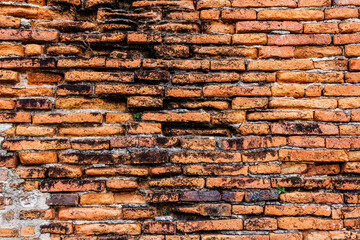 Ancient old red brick wall that has decayed in an old temple.