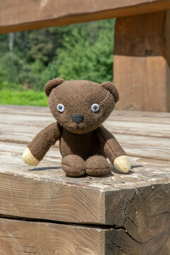 Skycov, Slovakia - August, 11, 2023 : A replica of Mr. Bean's Teddy Bear sitting on the wooden bench. Close up . Detail.
