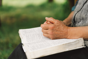 Bible, reading book or old woman praying for hope, help or support in Christianity religion or holy faith. Prayer or senior person studying or worshipping God in spiritual literature at outdoors