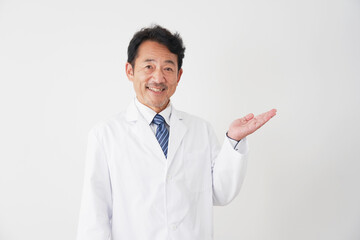 手のひらで右側を指すミドルエイジの医者　白背景