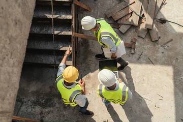 Top view, Team civil engineer inspection concrete pouring make stair at construction site. Teamwork...