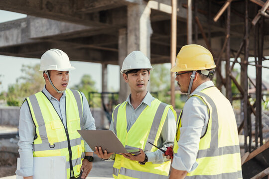 Building Project with Civil Engineer, Contractor and Architect discussing plan details. Team engineer inspection use computer laptop working at construction site. Teamwork discussing at workplace.