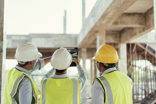 Civil Engineer and Contractor working in construction site. Team Architect working use BIM technology and digital construction application on digital tablet. Teamwork discussing at workplace.