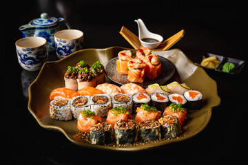 Japanese food | Sushi plates with soy sauce and chopsticks on a black table.