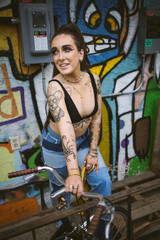 Young beautiful tattooed woman and graffiti street photography