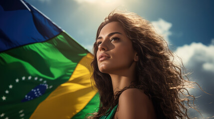 A beautiful young woman smiling hugging a Brazilian flag on Brazil's Independence Day.