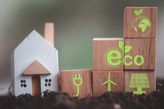 Miniature house with wood block with icons of eco house. Alternative and renewable energy for green ecology. Eco friendly construction conceptual image