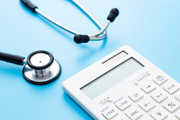 青背景に聴診器と電卓