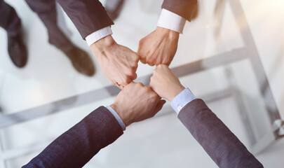 A group of successful businesspeople making fist bump together to cheer up, support and making a...
