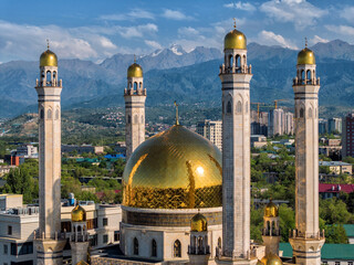 A beautiful mosque with golden domes in the Kazakh city of Almaty against the backdrop of mountains...