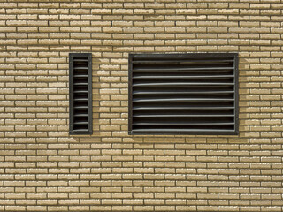 metal lattice of technical ventilation window on brick wall of renovated industrial building.