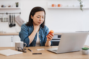Sick woman with sore throat holding pills during online talk