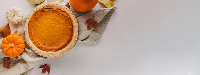 Banner with homemade pumpkin pie, pumpkins and dry leaves, Thanksgiving background