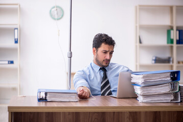 Young male employee suffering at workplace