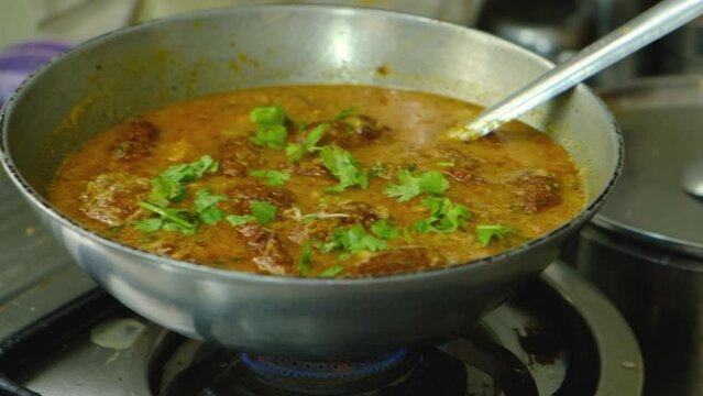 Garnishing with coriander vegetable Kofta curry in kadai which is an Indian Food, 4k, Close up shot 