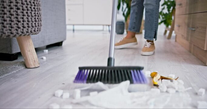 Broom, trash and closeup of woman sweeping in the living room of her modern apartment for hygiene. Equipment, dirt and zoom of female maid or cleaner cleaning the floor with dirt in lounge of a house