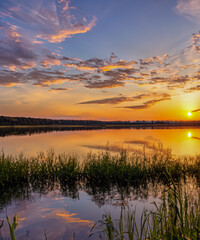 sunset at coast of the lake. Nature landscape. reflection, blue sky and yellow sunlight. landscape during sunset.