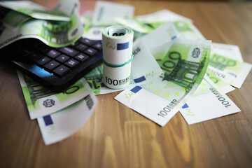 Computer keyboard and a scattering of 100 euro bills on the table. The work of a programmer and blogger on the Internet.