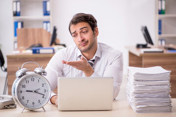 Young male employee in time management concept