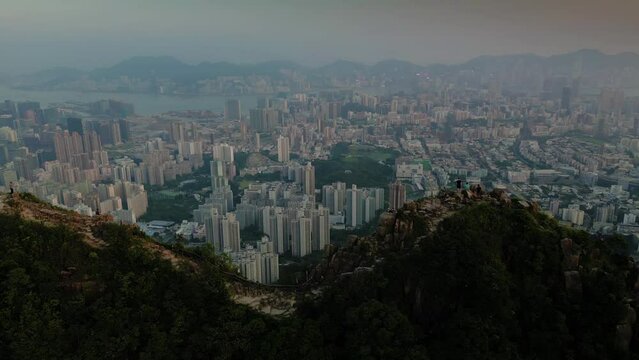 Aerial orbit shot of Lion Rock Hill and Hong Kong city at sunset