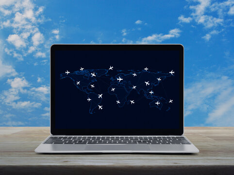 Flight routes airplanes connection and world map on laptop computer on wooden table over blue sky, Business airplane transportation network concept, Elements of this image furnished by NASA