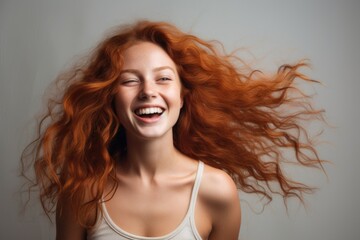 Radiant Redhead: Confident and Cheerful Young Woman with a Joyful Smile in a Secluded Studio Portrait