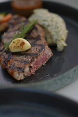 Steak Medium Rare with Mash Potato and Garlic in a Black Plate