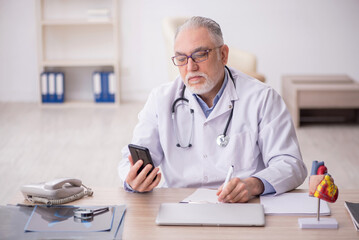 Old male doctor in telemedicine concept