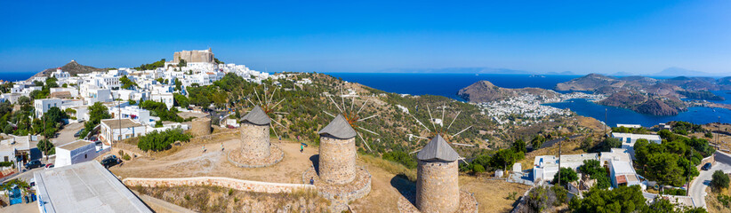The three windmills of Chora and iconic Monastery of Saint John the Theologian in chora of Patmos...