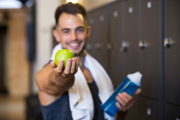 fitness man showing an apple to the camera