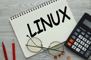 light wooden background with Linux text on the page. red pen