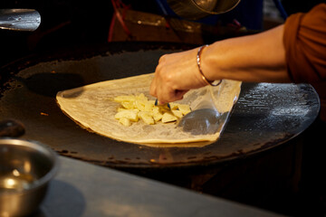 Fried Roti with banana  stuffed cooking  in the large pan

